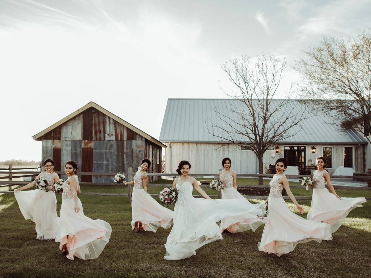 bride and bridesmaid spin around in dresses