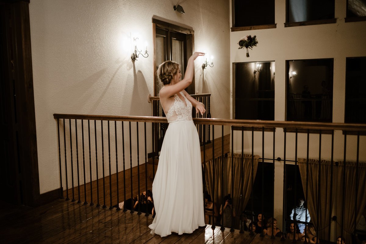 bride tosses bouquet over balcony