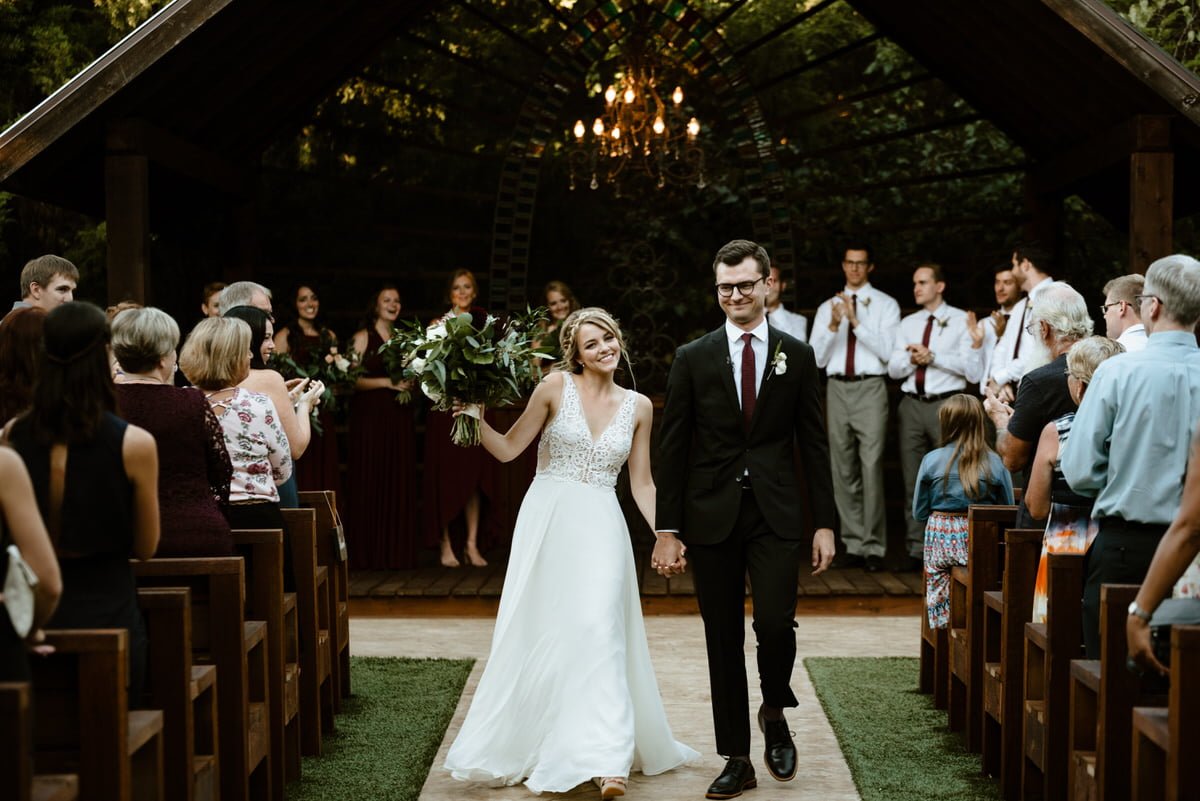 bride and groom walk down the aisle after marriage