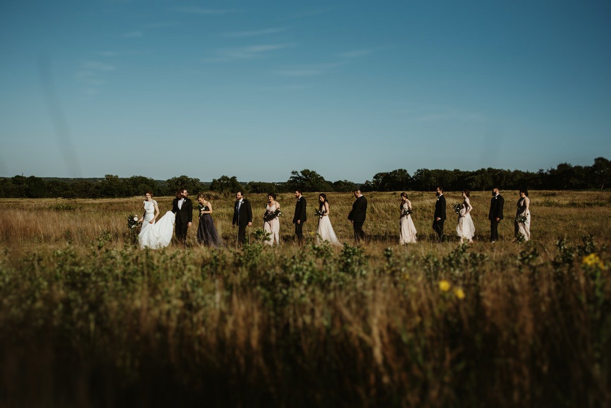 bridal party walking through field