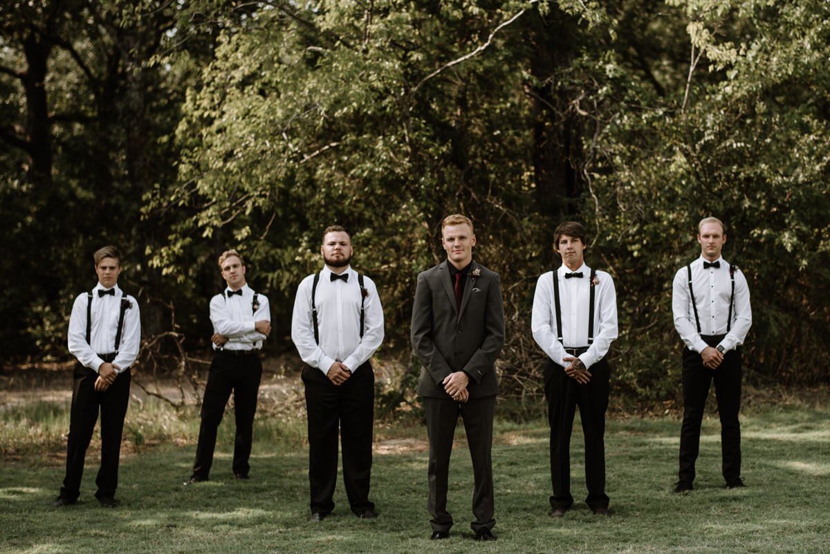 groomsmen posed in front of wooded area