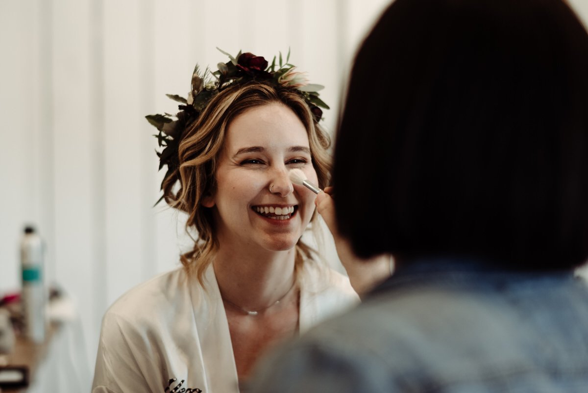 bride giggling while getting ready