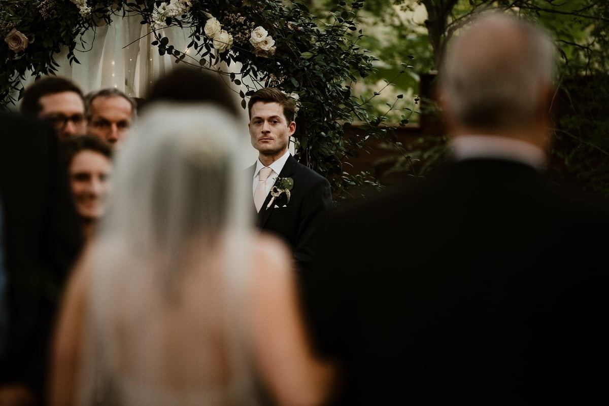 groom looking at bride down aisle