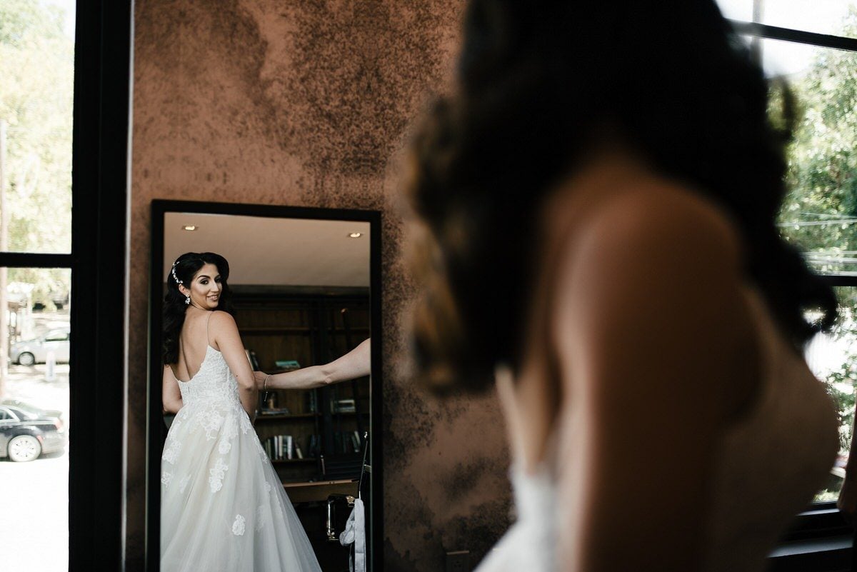 bride looks at herself in mirror