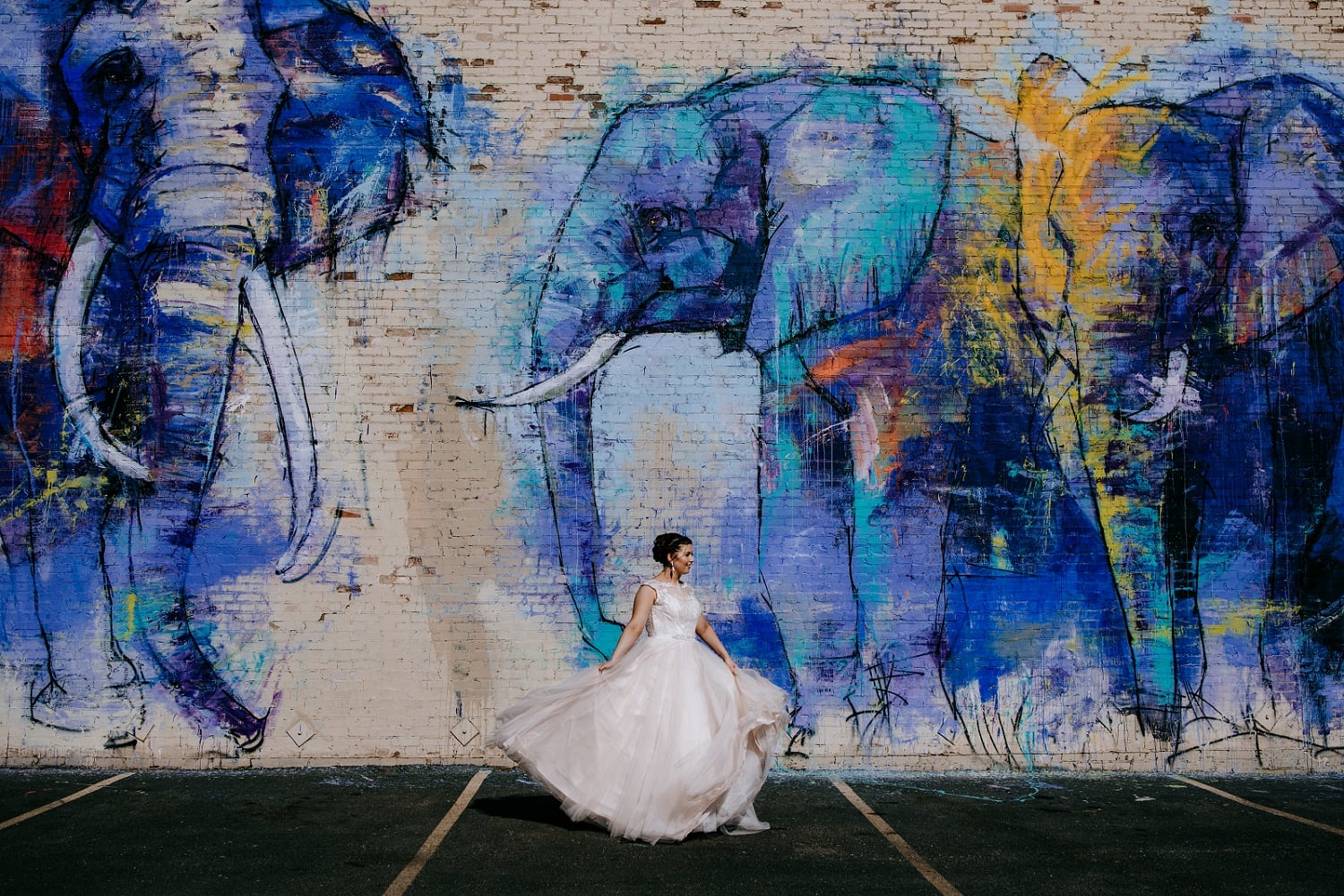 bride spinning around in front of mural
