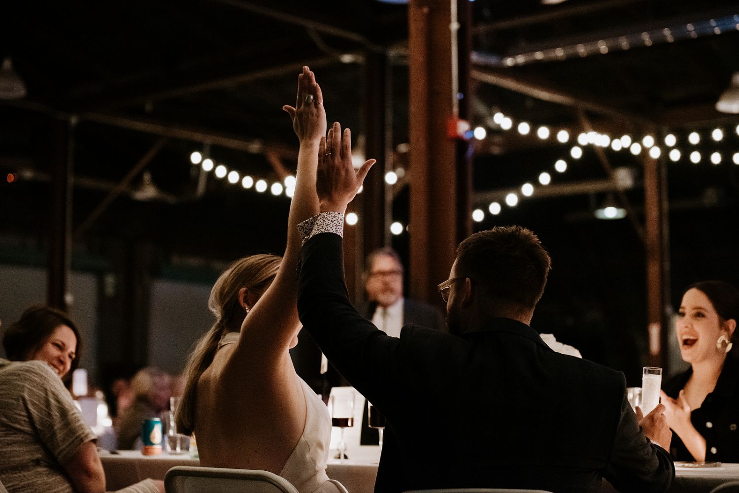 couple high fives during wedding speeches