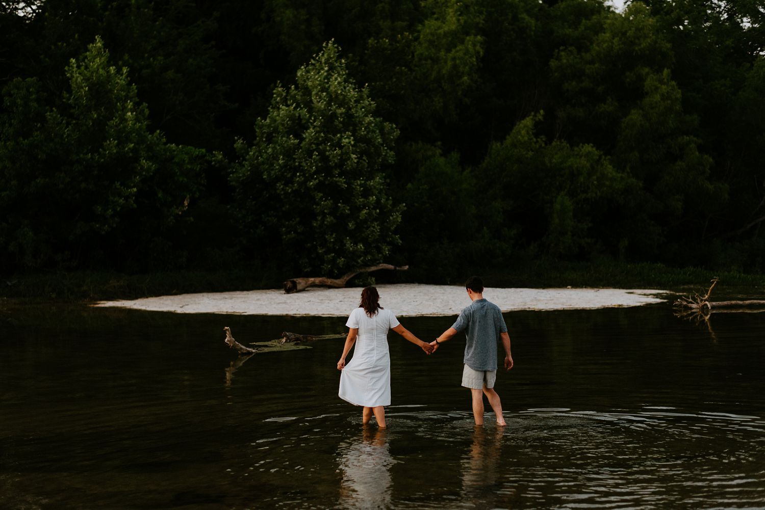 couple walks through water engagement session