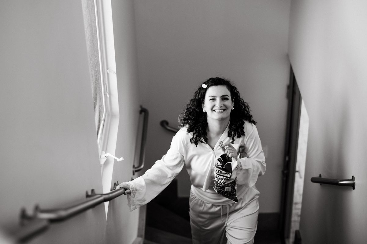 bride walking up stairs smiling at the camera