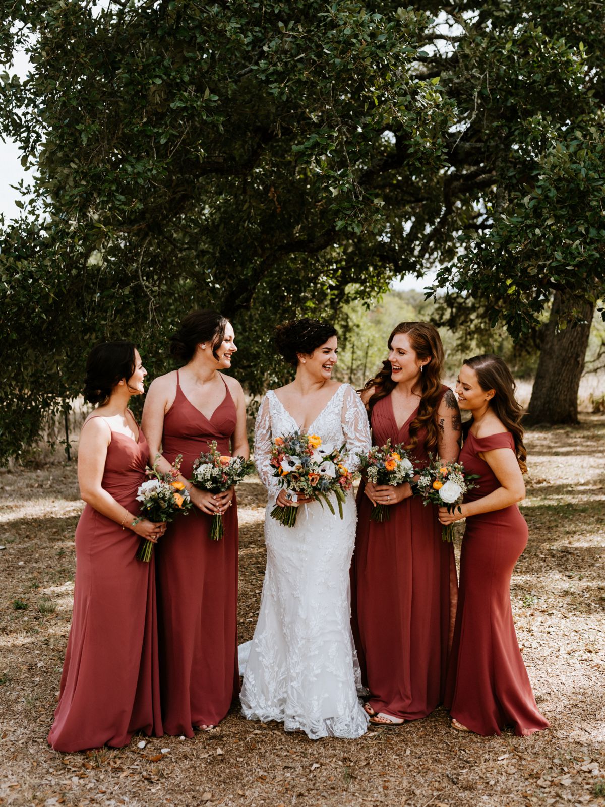 bridesmaids in pink dresses smiling at bride