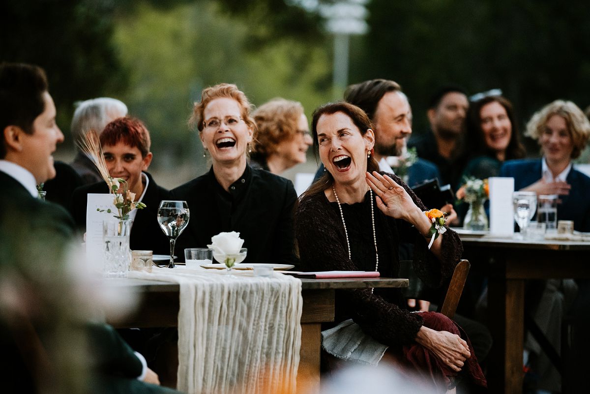 guests laughing intensely during wedding toasts