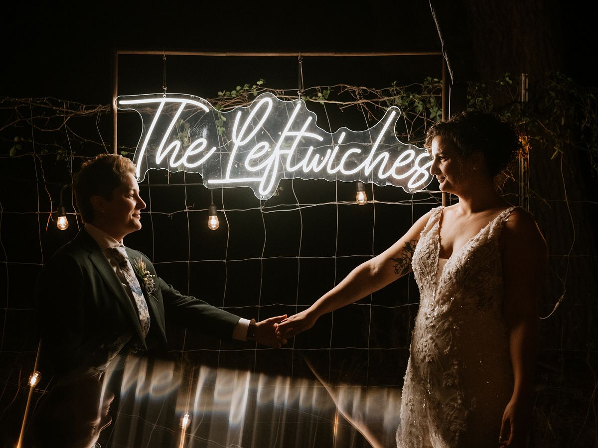 couple in front of neon sign at night 