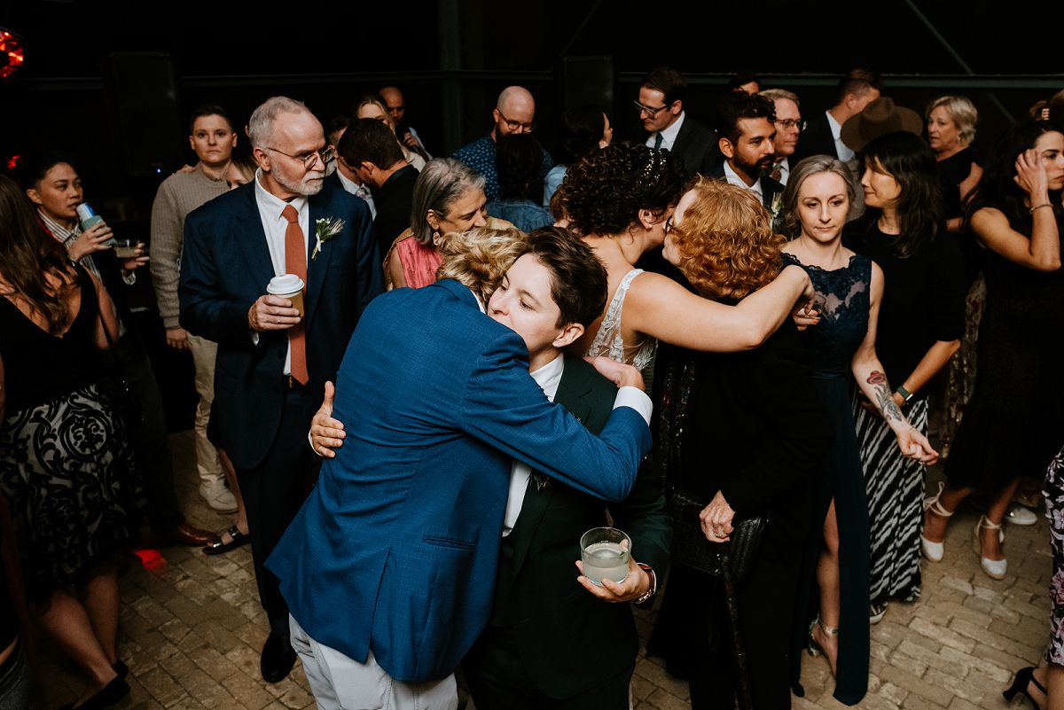 people hugging each other at wedding reception