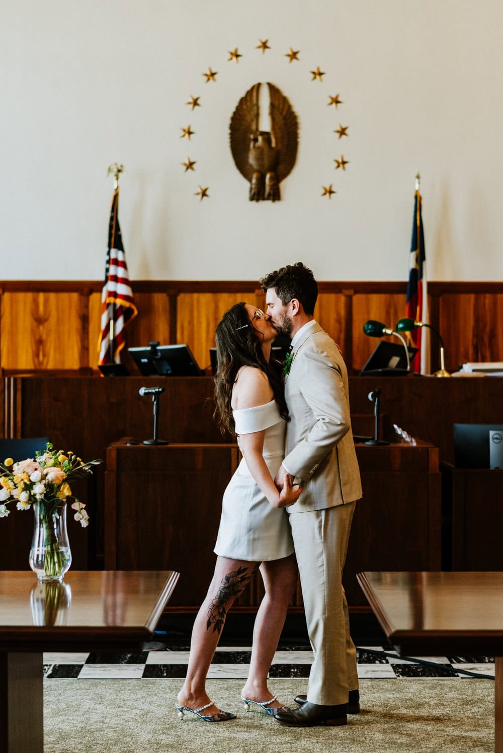 couple kissing during elopement in courthouse