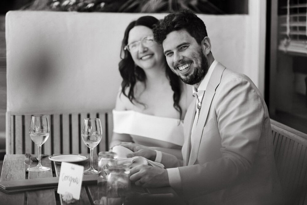 couple smiling at camera at restaurant during elopement