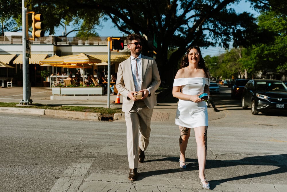 couple walks across crosswalk from restaurant