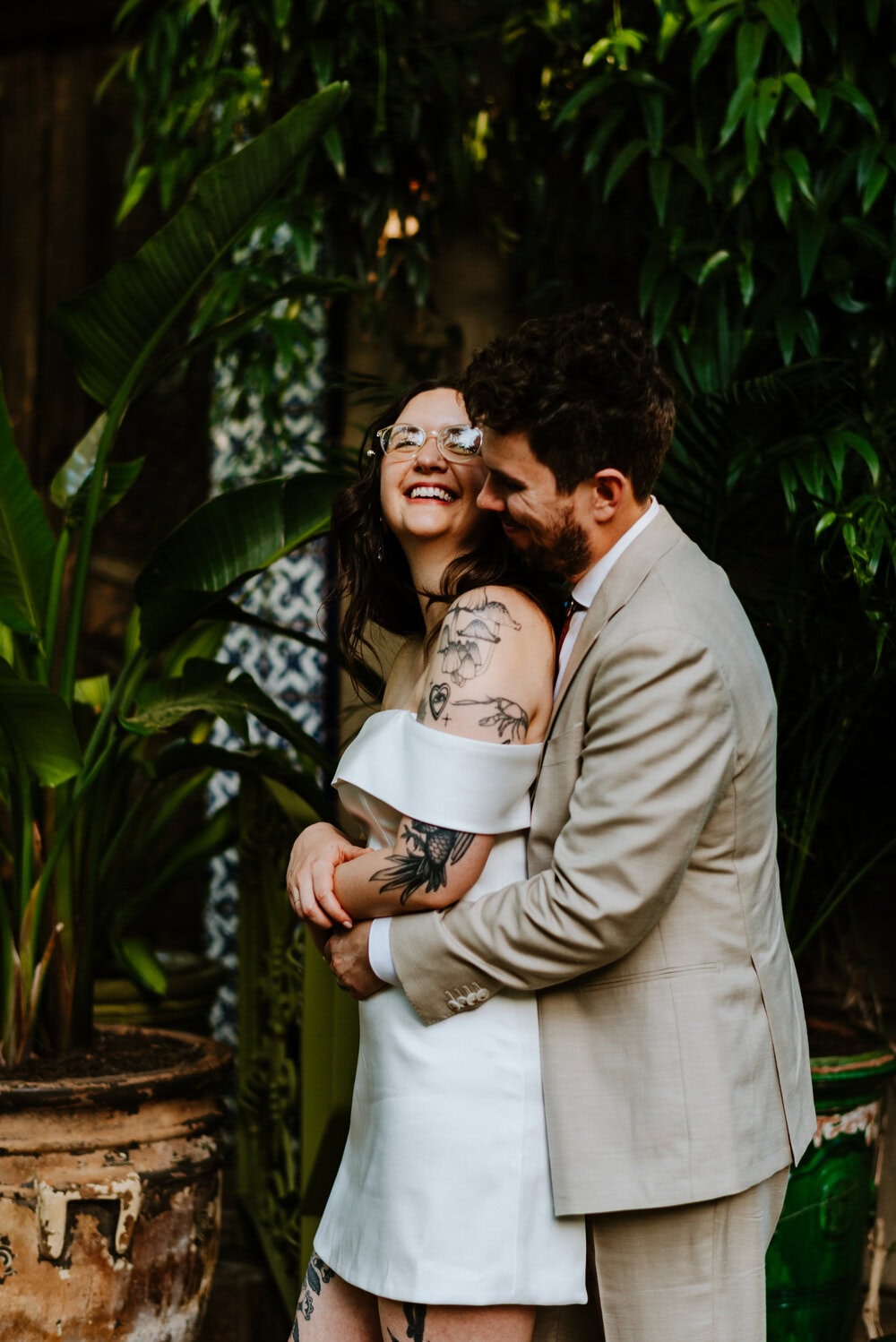 groom holding bride from behind while she laughs