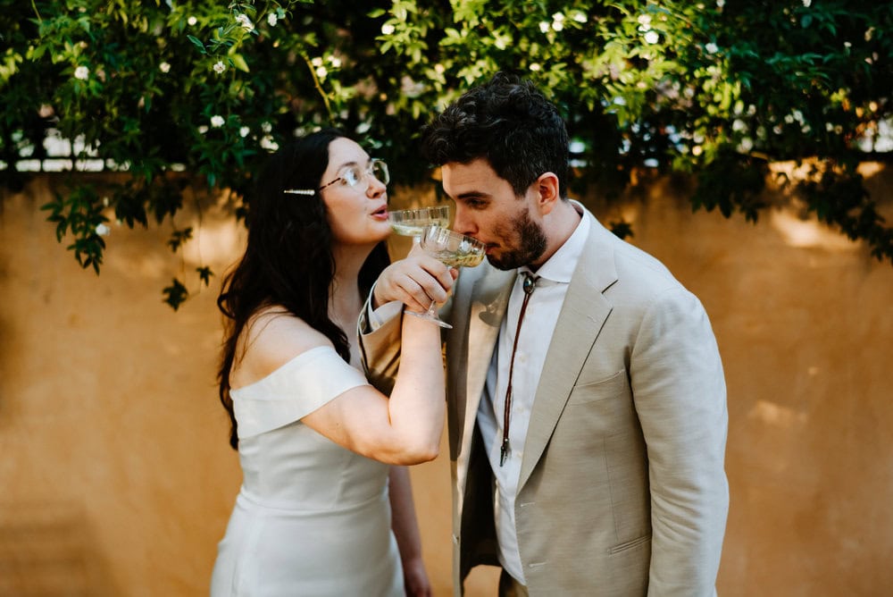 couple intertwines arms to drink wine from each other