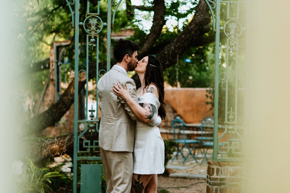 couple kisses in open artistic greenhouse