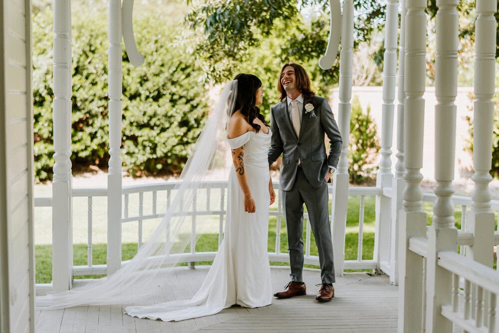 full body image of bride and groom laughing and smiling after seeing each other