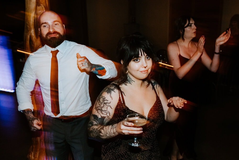 direct flash of people dancing and smiling during wedding reception