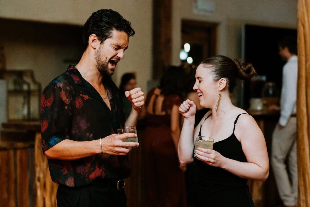 couple holding hands like they are holding microphones during wedding reception