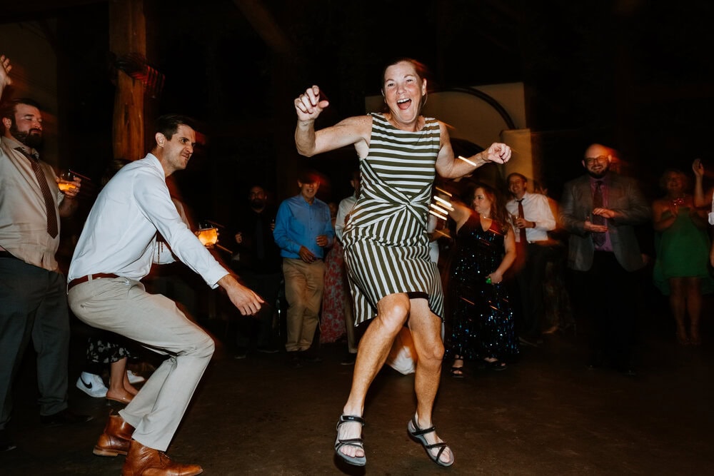 direct flash of people dancing and smiling during wedding reception