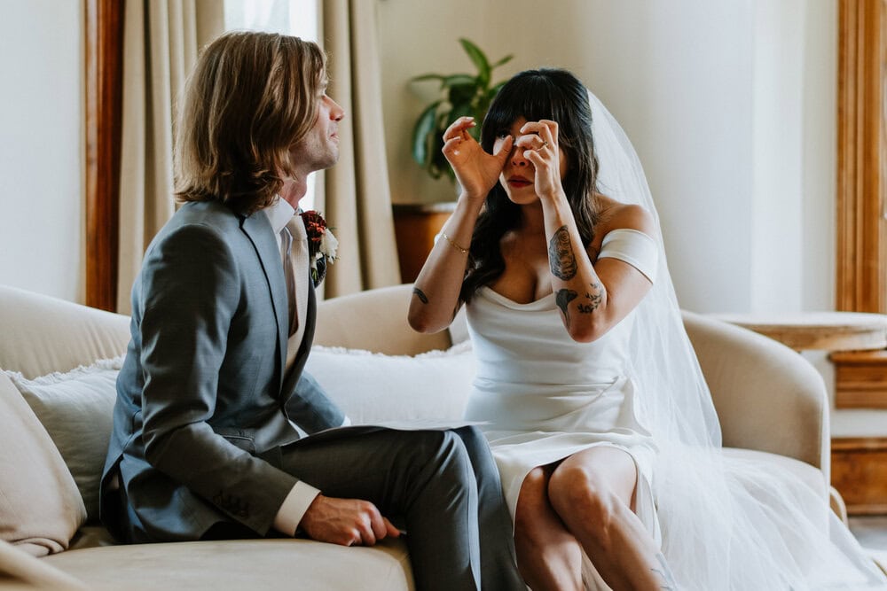 bride wipes away tears from her eyes after hearing grooms vows
