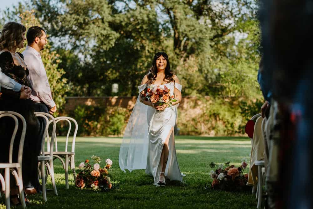 bride walking down aisle in dappled light