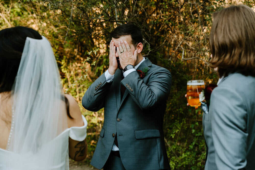groomsmen covers face with hands with joy after ceremony
