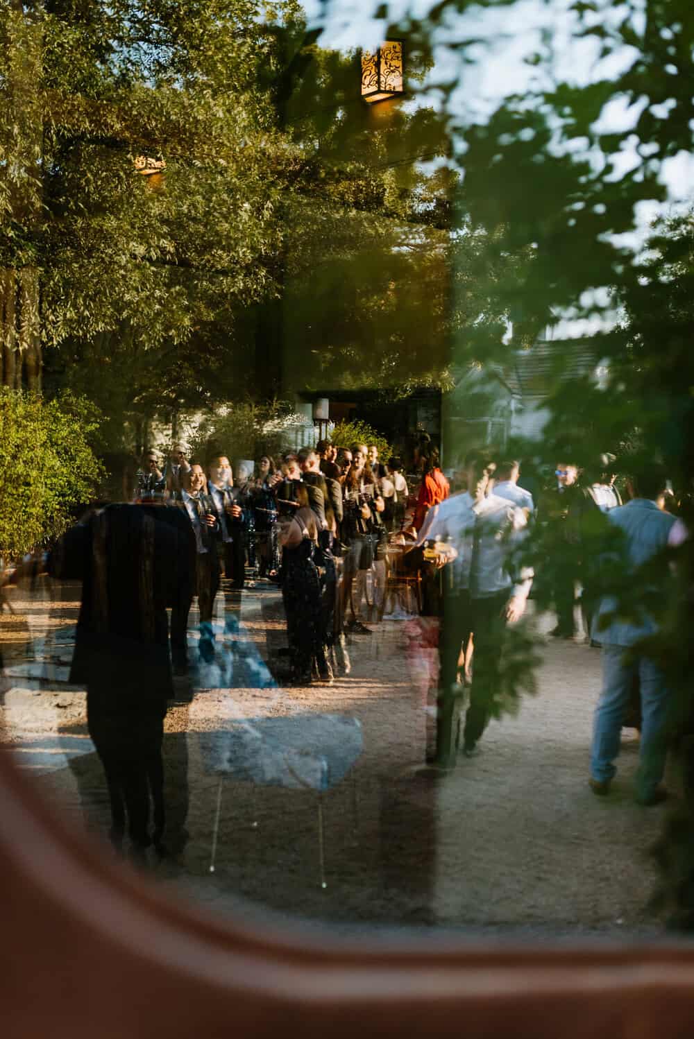 photo through window of guests hanging out during cocktail hour 