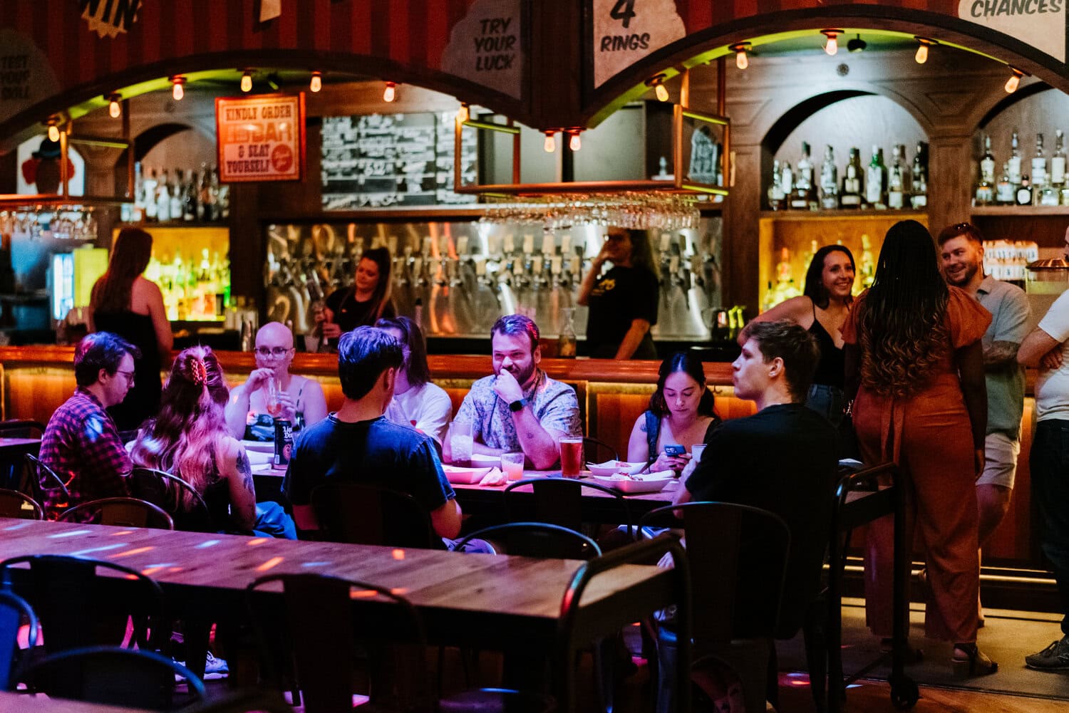friends of couple sitting inside dark room of Barrel O' Fun for reception