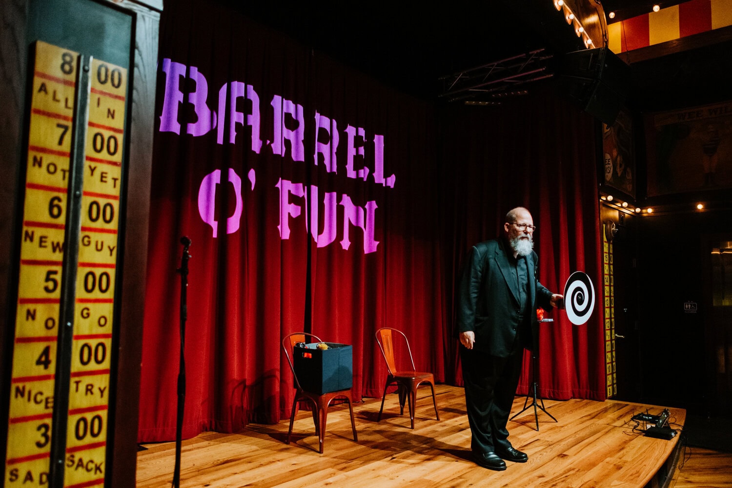 Brad Henderson standing on stage in Barrel O' Fun performing magician act